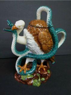 a figurine of a bird with a snake wrapped around it's neck