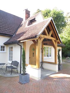 a small white house with wood trimmings and an awning over the front door