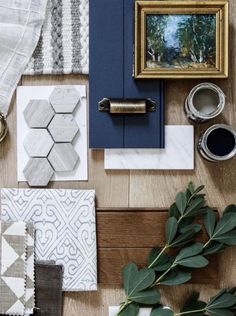 a wooden table topped with lots of different types of tile and decorating items on top of it