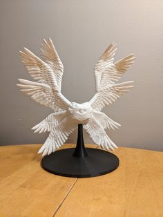 a white bird sculpture sitting on top of a wooden table