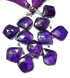 purple glass beads with tassels on a white background