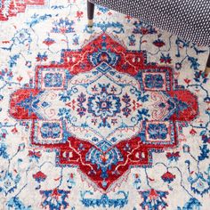 a red, white and blue area rug with an ornate design on the bottom corner