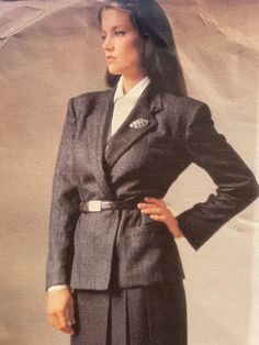 Loose-fitting, lined, above hip, wrap jacket has notched collar, slightly extended shoulders, side panels, welt and buttonhole pockets and long, two piece sleeves with mock vent and button trim.  Straight skirt, above ankle, has back button waistband, side front pleats and back zipper.  Very loose fitting blouse  has collar, extended shoulders, back pleated into yoke with slightly forward shoulder seams, pockets, flaps, shaped hemline and long sleeves with placket pleats and button cuffs. The pattern is complete with instructions.  The skirt portion is neatly cut, and the rest of the pattern is uncut. The envelope has some wear at the edges. Classic Skirt Suit With Buttons For Career, Classic Winter Skirt Suit For Career, Classic Winter Semi-formal Skirt Suit, Classic Skirt Suit With Notch Lapel, Tailored Lined Skirt Suit For Workwear, Classic Fitted Skirt Suit With Pockets, Classic Skirt Suit With Pockets For Work, Classic Skirt Suit For Fall Formal Occasions, Classic Skirt Suit For Formal Fall Occasions