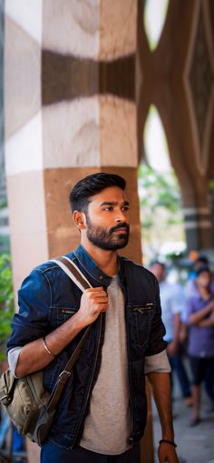 a man with a beard is walking down the street