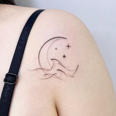 a woman's shoulder with a crescent tattoo on the left side of her arm