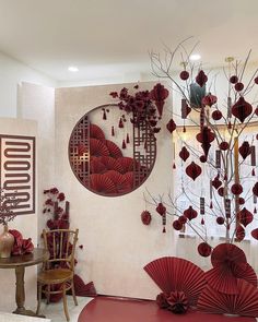 a living room filled with red furniture and art work on the wall above it's windows