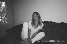 a black and white photo of a woman sitting on a bed