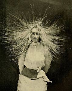 an old black and white photo of a woman with her hair blowing in the wind