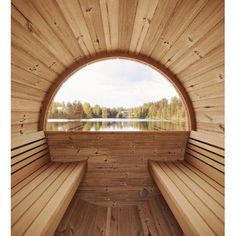 the inside of a sauna with wooden benches and a lake in the back ground