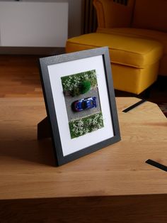 a photo frame sitting on top of a wooden table next to a chair and ottoman