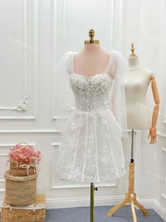 a mannequin with a white dress on display in front of two mannes