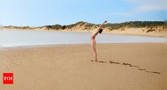 a woman is doing yoga on the beach