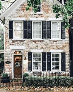 a brick house with black shutters and white trim