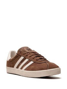 Adidas Gazelle 3-Stripes Leather Sneakers - Farfetch Adidas Leather Sneakers With Three Stripes, Classic Brown Sneakers With Vulcanized Sole, Classic Adidas Leather Sneakers, Classic Leather Adidas Sneakers, Leather Sneakers With White Sole And Three Stripes, Brown Adidas Sneakers With Rubber Sole, Leather High-top Striped Sneakers, Leather High-top Sneakers With Stripes, Adidas Brown Sneakers With Contrast Sole