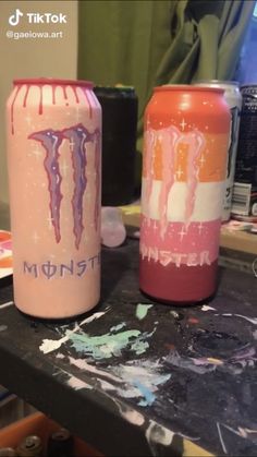 two painted cans sitting on top of a table