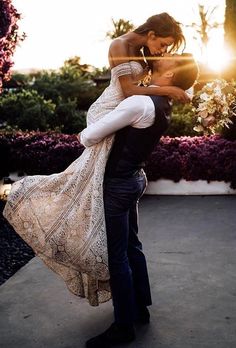 a bride and groom kissing in front of the sun