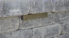 a close up of a stone wall with a metal plaque on it's side