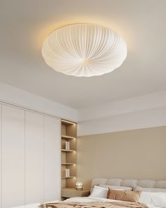 a large bed sitting under a round light fixture in a bedroom next to a book shelf