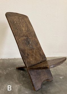 an old wooden object sitting on top of a cement floor