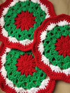 three crocheted coasters with red and green designs