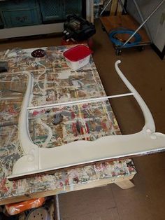 a sewing machine sitting on top of a table next to a wallpaper covered floor