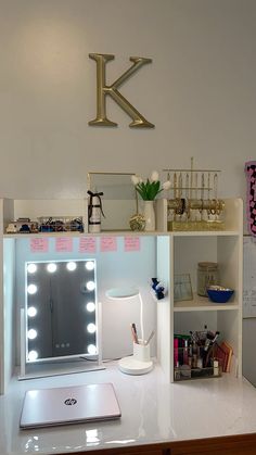 a white desk topped with a mirror and a laptop computer sitting on top of it