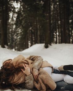 a woman laying in the snow with her arms around her head