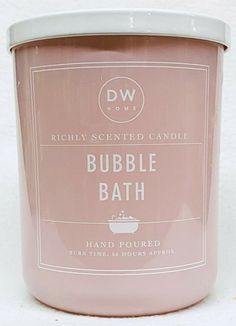 a pink candle that is sitting on a white surface with the words bubble bath printed on it