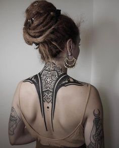 a woman with tattoos on her back and neck