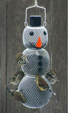 a snowman made out of bird feeders with birds on it's sides