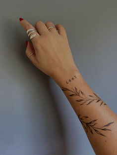 a woman's hand with a tattoo on her left wrist and the word cool written in small letters