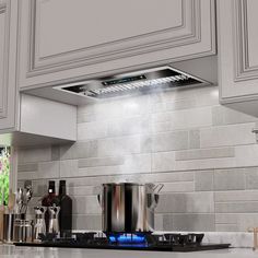 a stove top oven sitting inside of a kitchen next to white cabinets and counter tops