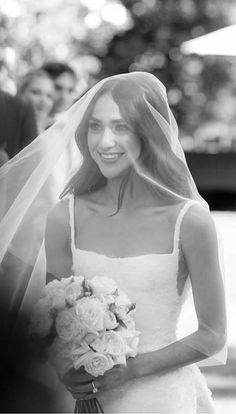 the bride smiles as she walks down the aisle