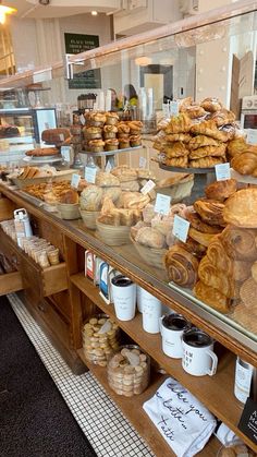 a bakery filled with lots of different types of breads and pastries on display