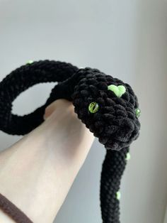 a black cat with green eyes is being held up by someone's hand,