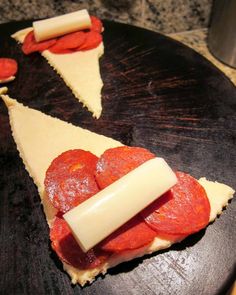 slices of pizza with cheese and pepperoni arranged on a black plate, ready to be eaten