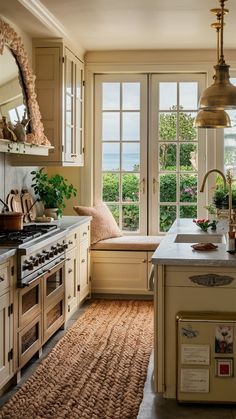 a kitchen with an oven, sink and window overlooking the ocean is pictured in this image