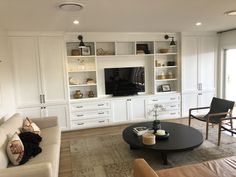 a living room filled with furniture and a flat screen tv on top of a wall