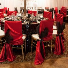 the table is set with red cloths and chairs