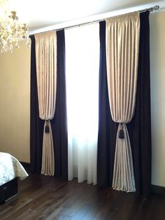 a bedroom with wood floors and white curtains