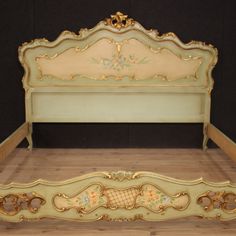 an ornate bed frame with gold trimmings on the headboard and foot board