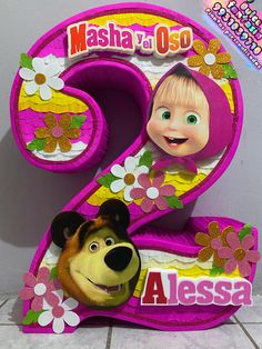 the number two with masha and oso on it is next to a cartoon character