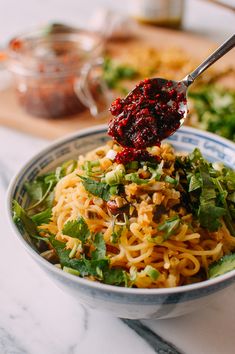 a bowl filled with noodles and vegetables on top of a table