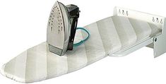 an ironing board is sitting on top of a white bed frame and has a cord attached to it