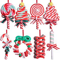 christmas ornaments hanging from strings on a white background, including candy canes and lollipops