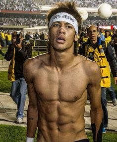 a shirtless man with no shirt on standing in front of a crowd at a soccer game