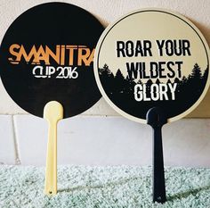 two black and white paddles with the words roar your wildest glory on them