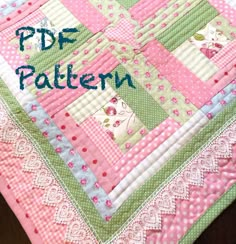 a pink and green patchwork quilt on a table