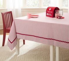 a table with a red mailbox sitting on top of it next to a window