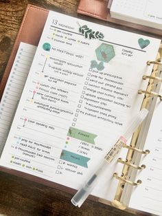 a planner and pen sitting on top of a wooden table